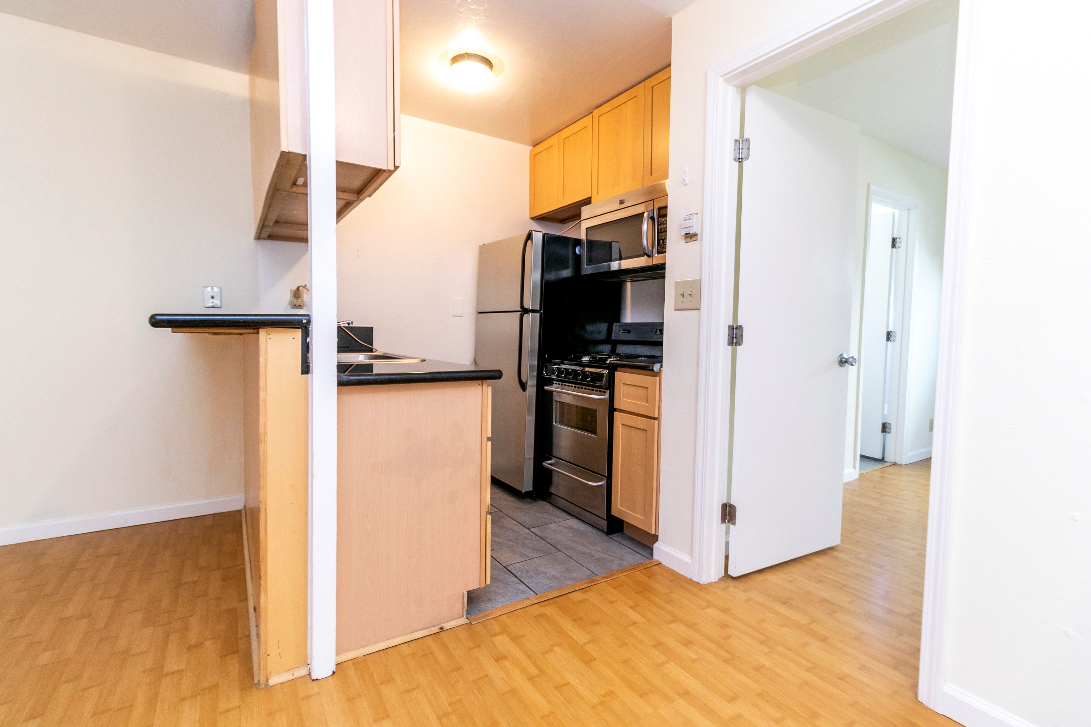 A kitchen with black appliances and wooden cabinets.
